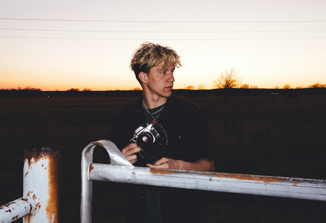 Portrait of a young male field reporter with a camera