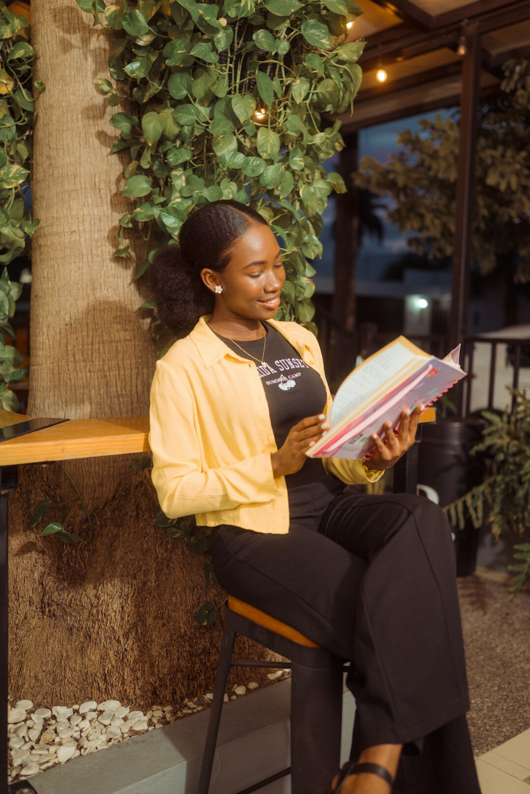 Smiling young woman reading a notebook in a cafe