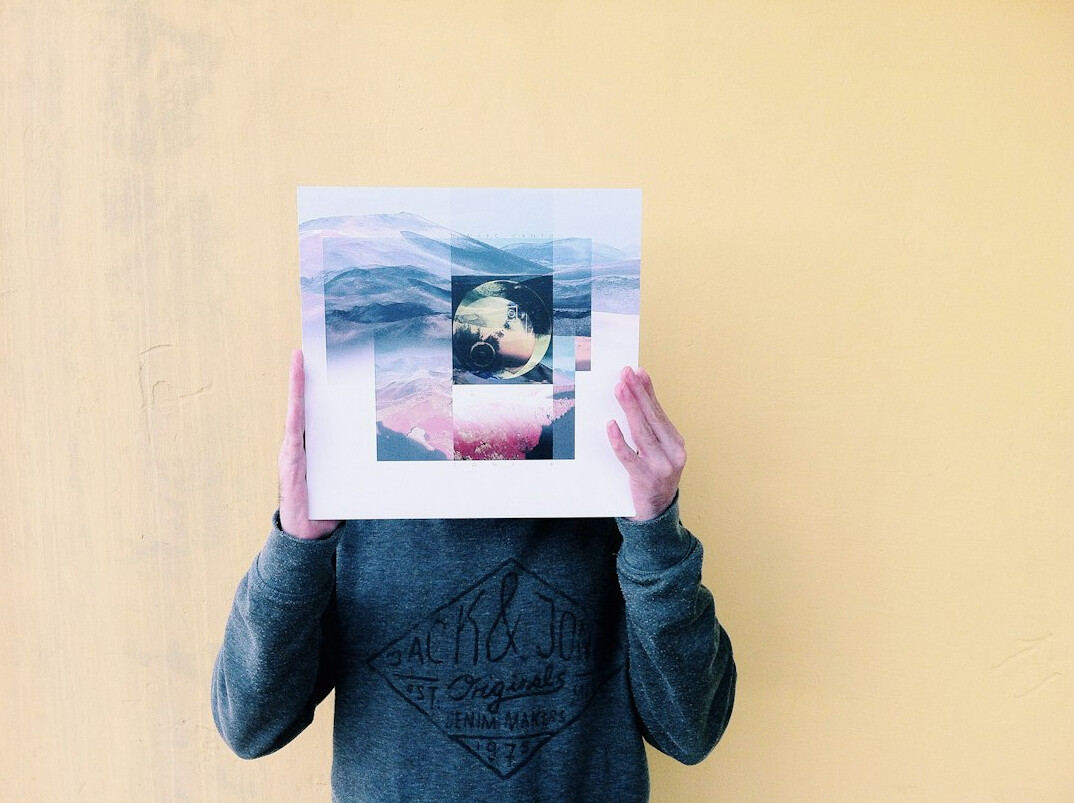 Young man with headphones holding a vintage photograph